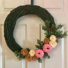 a wreath with doughnuts and greenery on it