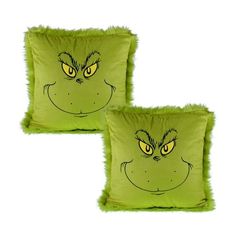 two lime green pillows with yellow eyes and furry furs on the front, one has an angry grin face