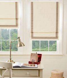 a desk with a lamp, books and pictures on the wall