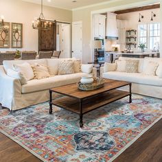 a living room filled with furniture and a rug on top of a hard wood floor