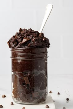 a glass jar filled with chocolate pudding on top of a table