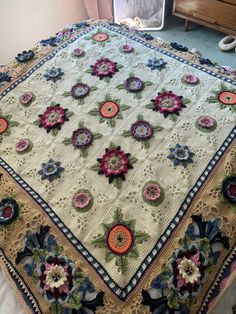 a crocheted blanket with colorful flowers on it