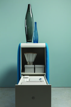 a blue and white cabinet with two vases on the top, and an open drawer in the middle