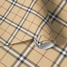 a tan and black plaid wallpaper with some scissors on it's end corner