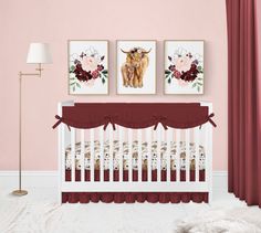 a baby crib with two pictures on the wall