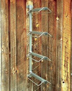 a tall metal shelf sitting on top of a wooden fence