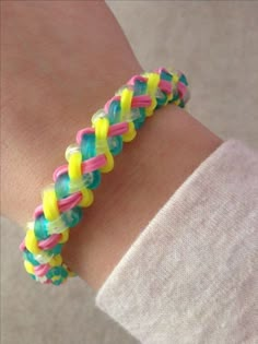 a woman's arm with a bracelet made out of neon colored plastic beads on it