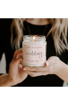 a woman holding a candle with the words best mom ever written on it in front of her