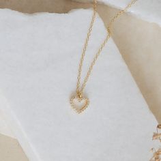 Whether you are celebrating a special occasion, or just feeling like treating yourself, this delicate necklace will become an everyday staple piece in your jewelry collection. The Forever Pave Heart Necklace is the perfect symbol of self-love and empowerment. With a diamond encrusted open heart charm, the design is perfect for brides and bridal parties, it's dainty enough to complement every look. Material: High-Quality Solid 925 Sterling Silver Finish: Sterling Silver ∙ 18K Gold Featuring a 9mm Pave Heart Necklace, Heart Necklace Diamond, Bridal Parties, Open Heart, Delicate Necklace, Diamond Heart, Staple Pieces, Solid 925 Sterling Silver, Heart Charm