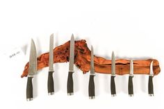 five knives are lined up in the shape of a long bone with several blades sticking out of it