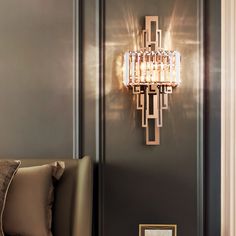 a living room with a couch and a chandelier hanging from the side wall