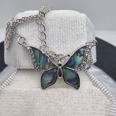 Dive into the mesmerizing beauty of the ocean and the sky with our Abalone Shell Blue Butterfly Necklace, a masterpiece forged in 925 Sterling Silver. Each flutter of the butterfly's wings reveals the ethereal dance of abalone shell's oceanic blues, accented with glimmers of crystal that catch the light like morning dew on a cobweb. The butterfly, an emblem of transformation and the promise of new beginnings, is poised in eternal grace, wings unfurled in a display of nature's unparalleled design Blue Butterfly Necklace, Mesmerizing Beauty, Butterfly Necklace, Abalone Shell, Sparkling Crystal, Blue Butterfly, Butterfly Wings, Sterling Silver Chains, Crystal Necklace