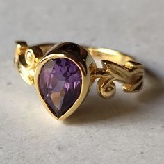 Material  14k Yellow Gold  . Gemstone  Natural Amethyst  . Gemstone Colour  Purple . Gemstone Shape  Pear   . Gemstone Size  6x6 MM . birthstone  February  . Cut Grade  Excellent . Style  Art Deco Luxury Yellow Gold Amethyst Ring With Bezel Setting, Exquisite Yellow Gold Amethyst Ring With Accent Stones, Luxury Gold Amethyst Ring With Bezel Setting, Formal Teardrop Amethyst Ring In Fine Jewelry Style, Exquisite Amethyst Ring, Exquisite Gold Amethyst Ring For Formal Occasions, Luxury Purple Pear-shaped Jewelry, Exquisite Amethyst Rings With Gemstone Accents, Exquisite Gold Amethyst Ring With Gemstone Accents