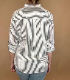 The Marina top is effortlessly beautiful with textured stripes, a split hem & a single chest pocket. Made from 100% cotton, this stylish striped shirt is versatile enough to pair with any casual denim and sandals or work wear. Let it be your go-to piece for classic, effortless fashion. Details: 100% Cotton Button up blouse Single front pocket Split hem Roll tab sleeves Fit: true to size, Amber is modeling size Small. Contents: 100% Cotton Imported Trendy Striped Workwear Shirt, Spring Horizontal Stripe Button-up Shirt, Trendy Tops With Contrast Stripes For Work, Casual Striped Blouse For Work, Spring Button-up Shirt With Horizontal Stripes, Casual Shirt With Contrast Stripes For Work, Casual Workwear Shirt With Contrast Stripes, Chic Cotton Top With Horizontal Stripes, Pinstripe Cotton Tops With Relaxed Fit