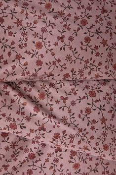 a pink flowered fabric with small red flowers on it