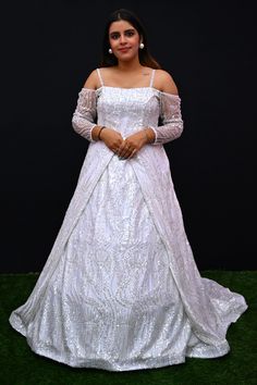 Its a stunning floor-length outfit made from Net fabric in an elegant White color. It features a Off -Shoulder Neck at the front and a Deep Neck at the back. The gown is designed with Cold Shoulder sleeves style. It is embellished with intricate work including Cutdana, Sequins, and Stone work, making it a beautiful choice for special occasions and events. Complete the look by wearing Stone jewelry and bracelet. There might be little color variations in the image and original product due to photo Fitted Off-shoulder Gown For Debutante Ball, White Festive Evening Dress For Wedding, Festive White Evening Dress For Wedding, Floor-length Embroidered Ball Gown For Debutante Ball, Floor-length Ball Gown With Intricate Embroidery For Debutante Ball, Debutante Ball Gown With Intricate Embroidery, Intricate Embroidery Gown With Fitted Bodice For Debutante Ball, Intricate Embroidery Gown For Debutante Ball, Intricate Embroidery Fitted Bodice Gown For Debutante Ball