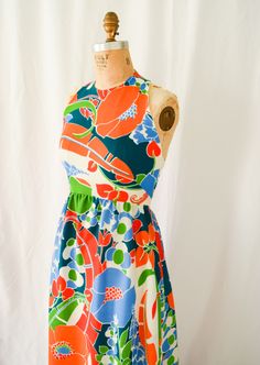 1960s Dress | Leo Narducci  | Vintage Late 60's Maxi Gown Bold Tropical Floral Print Halter Dress with Pockets Dress  DETAILS: *Late 1960s era dress *BOLD tropical floral print with blues, orange, red, green, and white *Fabric feels like a stable nylon acetate knit- spongy and light *Halter bodice with french darts *Buttons at back neck *Long maxi length gathered skirt *Side seam pockets *Back metal centered zipper LABEL: Leo Narducci Ambiance CONDITION: No flaws to note.  MEASUREMENTS: Bust= 36" Waist= 26" Hips= 46" Length from high point shoulder to hem= 57" Turned up hem= 2.5" Compare with your own measurements + ease or compare with similar garments in your closet.  SHIPPING: This item will ship via USPS Priority Mail domestically and international. All orders have insurance included. 1960s Dress, Printed Halter Dress, 1960's Dress, Maxi Gown, Tropical Floral Print, Late 1960s, Maxi Gowns, Gathered Skirt, Tropical Floral