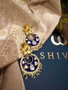 These gorgeous earrings will add a perfect charm to your occasion wear. You will definitely fall in love with this beauty and it will make you stand out among the crowd. Length: 6.5 cms Width: 3.5 cms One of a kind. The uncut Kundan stones embellished on a blue meenakari (enameled) base with pearl drop clusters make it a statement pair. The earrings are the same as shown in the pictures. We have only one piece in this design and color, hence you get what you see in the pictures. Temple Jewelry Danglers For Diwali Weddings, Diwali Wedding Temple Jewelry Danglers, Wedding Temple Jewelry Danglers With Cutdana, Temple Style Tilla Earrings For Wedding, Wedding Chandbali Jhumkas With Matching Earrings, Fusion Style Chandbalis For Festival Celebrations, Fusion Style Dangle Jhumkas For Wedding, Blue Temple Jewelry Chandbalis As Gift, Temple Jewelry Pearl Earrings With Meenakari For Party