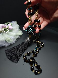 Beautiful sautoir necklace with long tassel. The main elements of this necklace are two: a large 30 mm pearl covered in beads and crystals and a splendid black tassel with Marcasite. These crystals give a lot of brightness and make the necklace very elegant. The pearl is covered by hand with different types of beads, a precision and difficult job to perform. The necklace is made with black agate beads of different sizes and crystals. Some points are highlighted with the beautiful emerald green color which gives a mystical look to the necklace. Everything matches perfectly, colors and shapes. The closure is an 18K gold-plated opening ring. The pendant with the ball and the tassel can be removed if desired and you can only wear the simple necklace. The necklace is very elegant, perfect for l Elegant Necklace With 108 Beads Pendant, Elegant Long Necklace For Jewelry Making With Gemstone Beads, Elegant Long Gemstone Beads Necklace For Jewelry Making, Elegant Long Necklace With Gemstone Beads For Jewelry Making, Elegant Jewelry With Tassels And Round Beads, Elegant Round Beaded Tassel Jewelry, Elegant Necklace With 108 Beads For Gift, Elegant Tassel Necklace With Round Beads, Elegant Tassel Necklaces As Gift