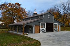 a large gray barn sitting in the middle of a field