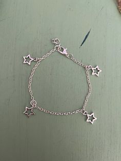 This is a handmade silver star charm bracelet. It's perfect on its own or for additional charms! Metal Charm Bracelet, Star-shaped Metal Bracelets As Gifts, Adjustable Star Charm Chain Bracelet, Sterling Silver Bracelets With Star Charm As A Gift, Adjustable Chain Bracelet With Star Charm As Gift, Dainty Silver Chain Bracelet With Star Charm, Adjustable Metal Bracelet With Star Charm, Dainty Silver Bracelet With Star Charm, Dainty Sterling Silver Bracelet With Star Charm