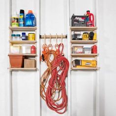 two shelving shelves holding various tools and other household care items, one with a cord attached to it