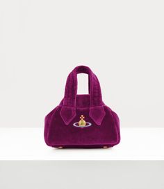 Our iconic Archive Mini Yasmine handbag, a new development of the house’s classic Yasmine style, was first presented at the Gold Label Autumn-Winter 1987/88 ‘Time Machine’ runway show. Named after the French designer Yasmine Eslami, who worked for Vivienne Westwood in the late ‘80s, the bag features a faded 'Union Jack' interior lining and cotton-velvet exterior panels, reflecting the opulent Neo-classical theme of this season. Vivienne Westwood Yasmine Bag, Purple Vivienne Westwood, Classical Theme, Yasmine Eslami, Exterior Panels, Eastpak Backpack, Purple Bag, Neo Classical, Late 80s