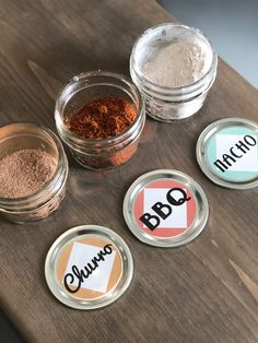 three jars filled with different types of spices on top of a wooden table next to each other