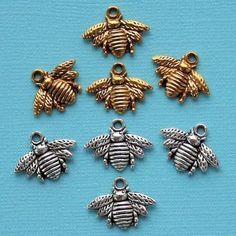 six bee charms in various sizes and colors on a blue background with the words bees written below them