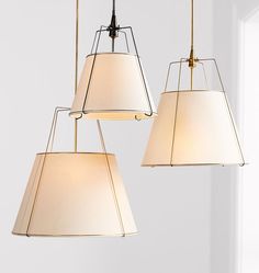 three lamps hanging from the ceiling in a room with white walls and flooring, one is