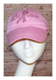 a white mannequin head wearing a pink hat with the word peace on it