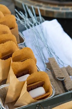 there are some food items in the tins on the table with napkins and forks