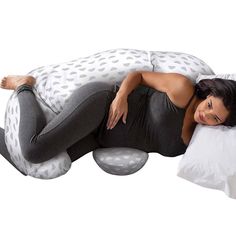 a woman laying on top of a large pillow