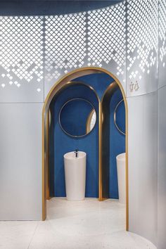 a blue and white bathroom with gold accents