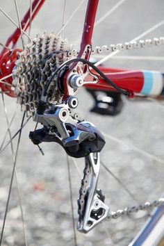 the rear wheel of a bicycle with gear on it's spokes and chain