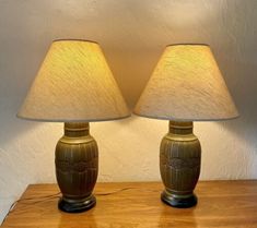 two lamps sitting on top of a wooden table