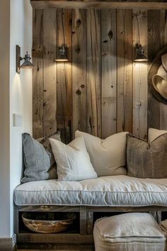 a couch with pillows and hats on it in front of a wooden wall