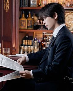 a man sitting at a bar reading a newspaper