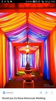 an aisle decorated with colorful drapes and lights