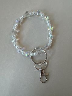 a white beaded bracelet with a pair of scissors