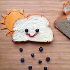 two slices of bread with blueberries and an orange sun on them, sitting next to each other