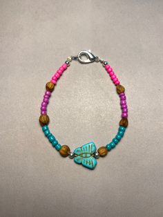 Introducing our Navajo-inspired beaded bracelet, a vibrant celebration of tradition and craftsmanship. Handcrafted with care, this stunning piece features a captivating blend of pink, purple, and blue beads, accented with juniper beads for a unique touch. Adorning the center is a small faux turquoise butterfly, adding a touch of Southwest charm. Measuring between 16.5cm to 17cm  in length, this bracelet exudes elegance and grace, perfect for everyday wear or as a meaningful gift honoring Native Bohemian Hand-strung Friendship Bracelets For Festivals, Blue Bohemian Beaded Bracelets With Wooden Beads, Bohemian Blue Beaded Bracelets With Wooden Beads, Beach Festival Bracelet Jewelry, Bohemian Beaded Bracelets With Wooden And Heishi Beads, Bohemian Blue Bracelets With Wooden Beads, Colorful Beaded Bohemian Stretch Bracelet, Colorful Bohemian Beaded Stretch Bracelet, Bohemian Turquoise Beaded Bracelets With Wooden Beads