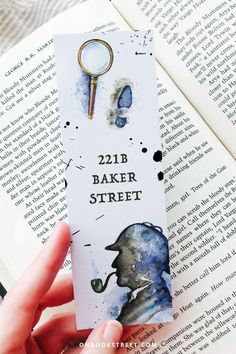 a bookmark with a key hanging from it's side next to an open book