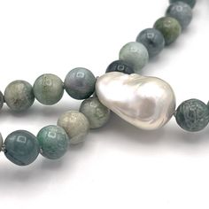 Imagine warm tropical water, dreamy green colors that change when the sun rises or sets. Imagine wearing a one of a kind piece of jewelry that gives you these beachy feels and more. Our Burmese aka multicolor Green Jade necklace makes a statement, at the beach, on vacation, or even an office. A single white Baroque pearl is the focal piece, and adds a simple, yet elegant charm. Not your everyday pearl necklace; this is sure to be a favorite for lovers of surf, sea and sand. Approximately 30 inch Elegant Green Necklace For Beach, Ocean-inspired Green Beaded Jewelry, Green Long Necklace For Beach, Unique Green Necklace For The Beach, Long Green Necklaces For The Beach, Handmade Ocean-inspired Necklace With Round Beads, Handmade Green Strand Jewelry, Green Moss Agate Round Bead Necklaces, Green Moss Agate Round Bead Necklace