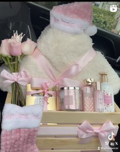 a teddy bear sitting in the back seat of a car with pink flowers and personal care products