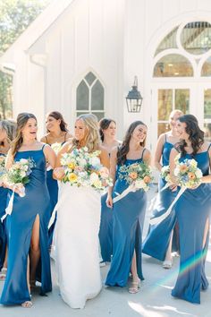 a group of bridesmaids standing in front of a church