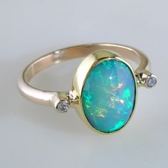 Fine Jewelry Oval Cabochon Opal Ring, Oval Cabochon Opal Ring Fine Jewelry, Ethiopian Opal Oval Rings For Anniversary, Oval Cabochon Opal Ring In Fine Jewelry, Classic Oval Opal Ring With Bezel Setting, Oval Opal Rings With Polished Finish, Classic Oval Bezel Set Opal Ring, Formal Opal Ring With Diamond Accents, Heirloom Oval Opal Ring