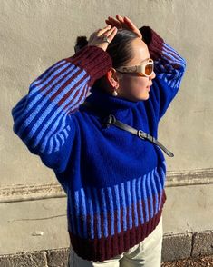 a woman wearing sunglasses and a blue sweater