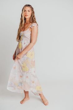 Look effortlessly pretty in our romantic Tuva Flutter Sleeve Maxi. With its pastel hues and enchanting floral pattern, this dress will have you feeling like a fairy-tale princess. Its open back detail and flutter cap sleeves make it both sophisticated and charming; pair it with a straw clutch and heeled sandals for your next special occasion. FIT: Runs true to size. Size up for maternity. MODEL: Mackenzie is 5’7” / 130lb / wearing a small. MATERIAL: 100% Polyester. GARMENT DETAILS: Pastel floral Feminine Cap Sleeve Summer Dress, Spring Whimsical Flutter Sleeve Dresses, Feminine Ruffled Cap Sleeve Dresses, Feminine Cap Sleeve Dresses With Ruffles, Feminine Dresses With Ruffles And Cap Sleeves, Feminine Flutter Sleeve Midi Dress For Garden Party, Feminine Ruffle Sleeve Midi Dress For Beach, Feminine Midi Dress With Ruffle Sleeves For Beach, Spring Cap Sleeve Flowy Dress