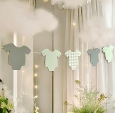 there are some baby ones hanging on the clothes line in this room with white curtains